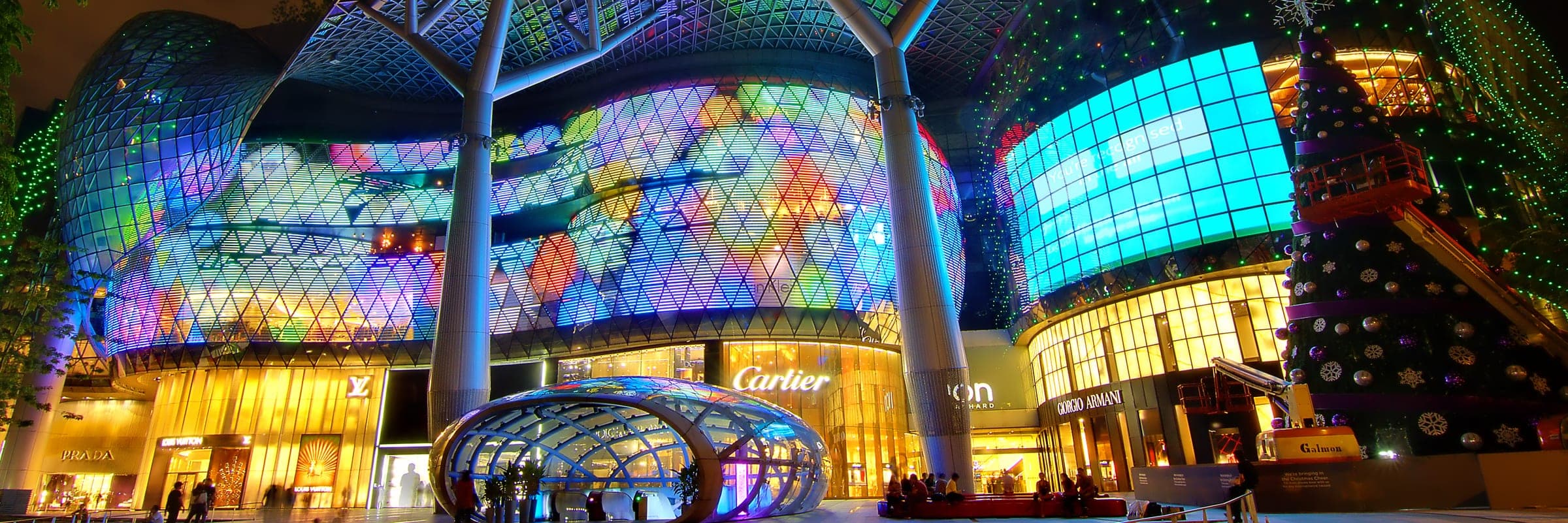 The glass front of ION Orchard on Orchard Road, Singapore, lit at dusk.